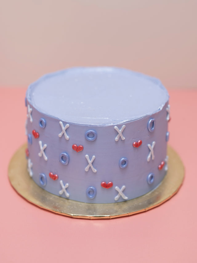 Small round cake with decorative elements on a pink background