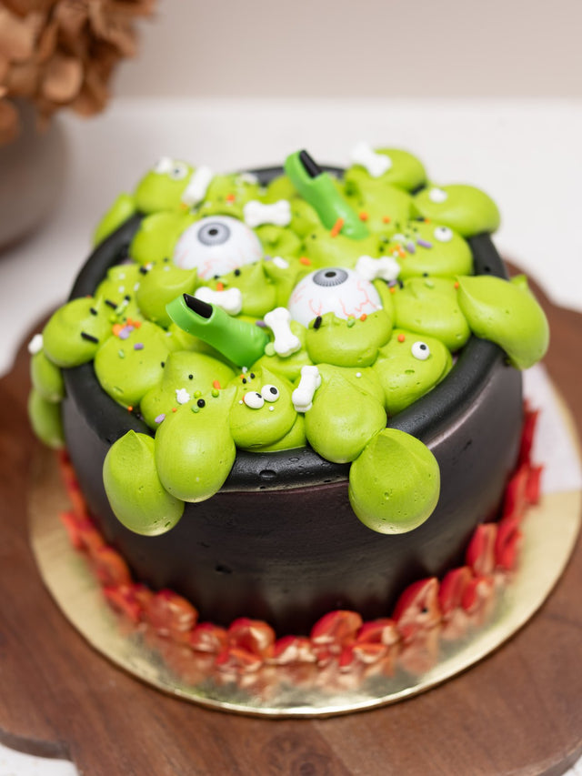 Halloween cauldron cake with green buttercream ooze