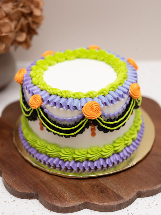 Halloween cake with purple, green and orange piped swags